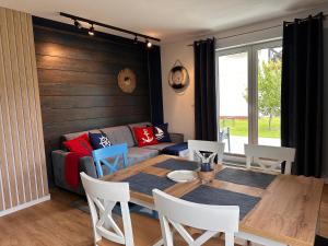 a living room with a table and a couch at Apartament szafirowy z basenem koło Łeby in Żarnowska