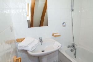 a white bathroom with a sink and a mirror at Gîte Gîtes de France 9/11 personnes à Brion in Brion