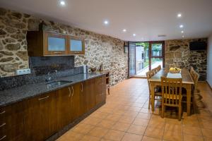 a kitchen with a table and a dining room at Casa Rural Antonio de Sofia in César