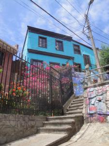 a blue house with a fence and stairs in front at The Travelling Chile in Valparaíso