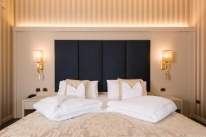 a bedroom with a large bed with two white pillows at Villa Nicolli Romantic Spa Resort - Adults Only in Riva del Garda