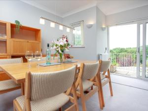 a kitchen and dining room with a wooden table and chairs at Leighwood Cottage in Paignton