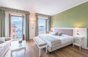 a bedroom with a large bed and a large window at Hotel Garni Corona in Menaggio