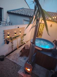 a backyard with a hot tub on a patio at Suite romantique avec jacuzzi privatif in Piolenc