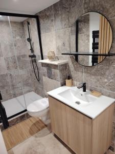 a bathroom with a sink and a toilet and a mirror at Suite romantique avec jacuzzi privatif in Piolenc +2 photos