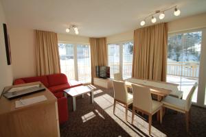 a living room with a red couch and a table at Appartements Andy in Obergurgl