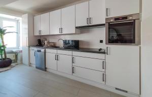 a kitchen with white cabinets and a sink and a microwave at Pet Friendly Apartment In Oostende With Wifi in Ostend