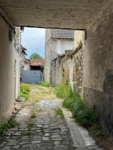 un callejón en un viejo edificio con un túnel en Le Perchoir de Linas, en Linas
