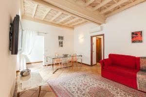 a living room with a red couch and a table at A Window on Pantheon in Rome