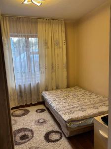 a small bedroom with a bed and a window at Гостевой дом Altyn Dan in Kegen