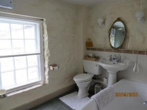 a bathroom with a toilet and a sink and a window at Eastview Bed and Breakfast in Garrigill +14 photos