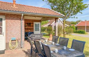 a wooden table and chairs on a patio at Cozy Home In Hoge Hexel With Sauna in Hoge-Hexel +19 photos