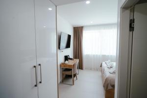 a hotel room with a desk and a bed and a television at Hotel Park in Valpovo