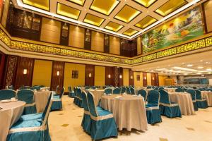 einen Bankettsaal mit weißen Tischen und blauen Stühlen in der Unterkunft Nan Guo Hotel in Guangzhou + 143 Fotos