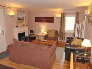 ein Wohnzimmer mit einem Sofa und einem Tisch in der Unterkunft Bramble Cottage 1, 2 & 3 in Lochdon