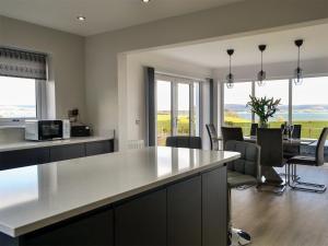 a kitchen and dining room with a table and chairs at Dinduff Lodge in Challoch