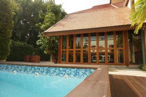 a house with a swimming pool with a building at Mon Muang Hotel in Chiang Mai