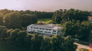 an aerial view of a large white building with trees at Hotel Park in Valpovo