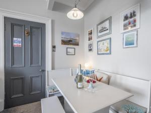 a room with a white table and a black door at Pier Haven - Cottage in Blairmore