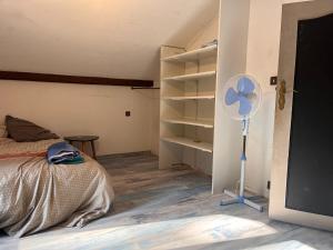 une chambre avec un lit et un ventilateur dans une pièce dans l'établissement Chambre Cosy , sub et wc privatif , chez l'habitant avec piscine, à La Celle-sous-Gouzon