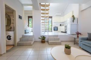 a living room with a staircase and a blue couch at Veranda Seaview Residence in Pefkochori