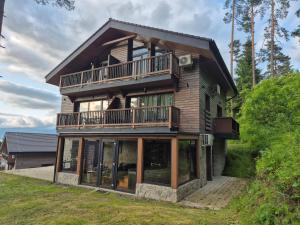 a large wooden house with a balcony and windows at Apartmán pod Demänovskou horou in Demanovska Dolina