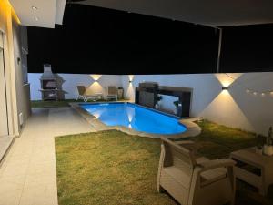 a large swimming pool in a house at night at Villa Luna in Hennchir Ksar Rhaleb +7 photos