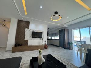 a living room with a couch and a tv on a wall at Villa Luna in Hennchir Ksar Rhaleb