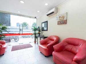 クアラルンプールにあるOYO 89717 Budget Star Hotelのリビングルーム(赤い椅子2脚、窓付)