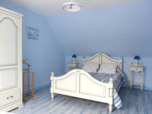 1 dormitorio con 1 cama blanca y paredes azules en Gîte de Kervoas, en Lézardrieux