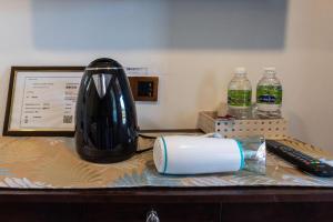 a desk with a hair dryer and a bottle of water at OYO 90149 Pua Family Semporna in Bulingisan +49 photos