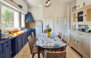 a kitchen with a table and chairs and a kitchen with blue cabinets at 3 Bedroom Amazing Home In Plouhinec in Plouhinec