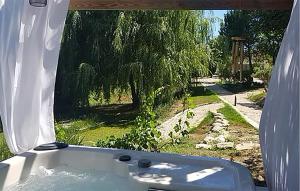a bath tub with a view of a yard at Maison Avec Jacuzzi in Mazan