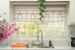 eine Küche mit Spüle und einem Fenster mit Blumen in der Unterkunft Agape's House in Murcia