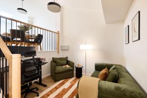 a living room with a green couch and a desk at The Brass Bear in Darlinghurst in Sydney