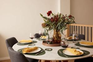 a table with plates of food and a vase of flowers at The Brass Bear in Darlinghurst in Sydney