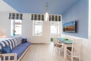 a living room with a blue couch and a table at Haus Zobler in Binz