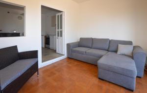 una sala de estar con un sofá y una silla en Appartement Calanches Piana, en Piana