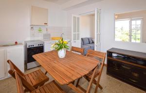 Una cocina y un comedor con mesa y sillas de madera. en Appartement Calanches Piana, en Piana