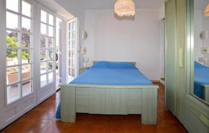 1 dormitorio con 1 cama con sábanas azules y ventanas en Appartement Calanches Piana, en Piana