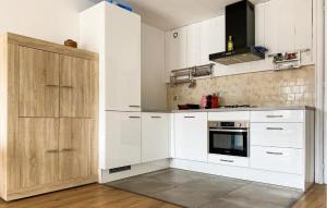 eine Küche mit weißen Schränken und einem Herd in der Unterkunft Nice Apartment In Bergen Aan Zee in Bergen aan Zee