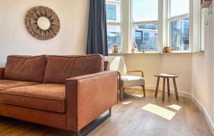 ein Wohnzimmer mit einem braunen Sofa und einem Stuhl in der Unterkunft Nice Apartment In Bergen Aan Zee in Bergen aan Zee