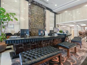 a lobby with a bar with two chairs and a counter at CP Peninsula Hotel in Dongguan +284 photos