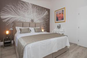 a bedroom with a large bed with a white bedspread at Villa Miramel mit privaten Swimmingoool - Makarska Exklusiv in Makarska +16 photos