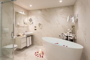 a bathroom with a tub and a toilet and a sink at Villa Nicolli Romantic Spa Resort - Adults Only in Riva del Garda