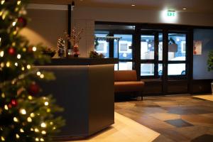 a christmas tree in the lobby of a office at Elvehagen Hotell in Sande +4 photos