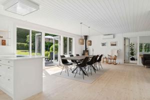 a kitchen and dining room with a table and chairs at Spacious, Lovely Cottage In North Zealand in Melby