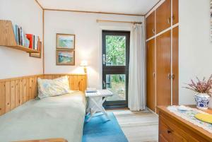 une chambre avec un lit, un bureau et une fenêtre dans l'établissement Lovely Cottage Close To The North Sea, à Pandrup