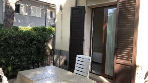a table and a white chair on a patio at Camera Il gabbiano in Marina di Campo