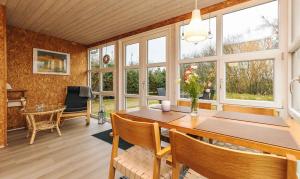 ThyholmにあるCozy Holiday Home With View Of Lyngs Dragのテーブルと椅子と窓のあるダイニングルーム